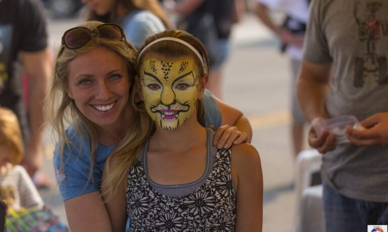 female face painter with girl she face painted as a cheetah cheetah